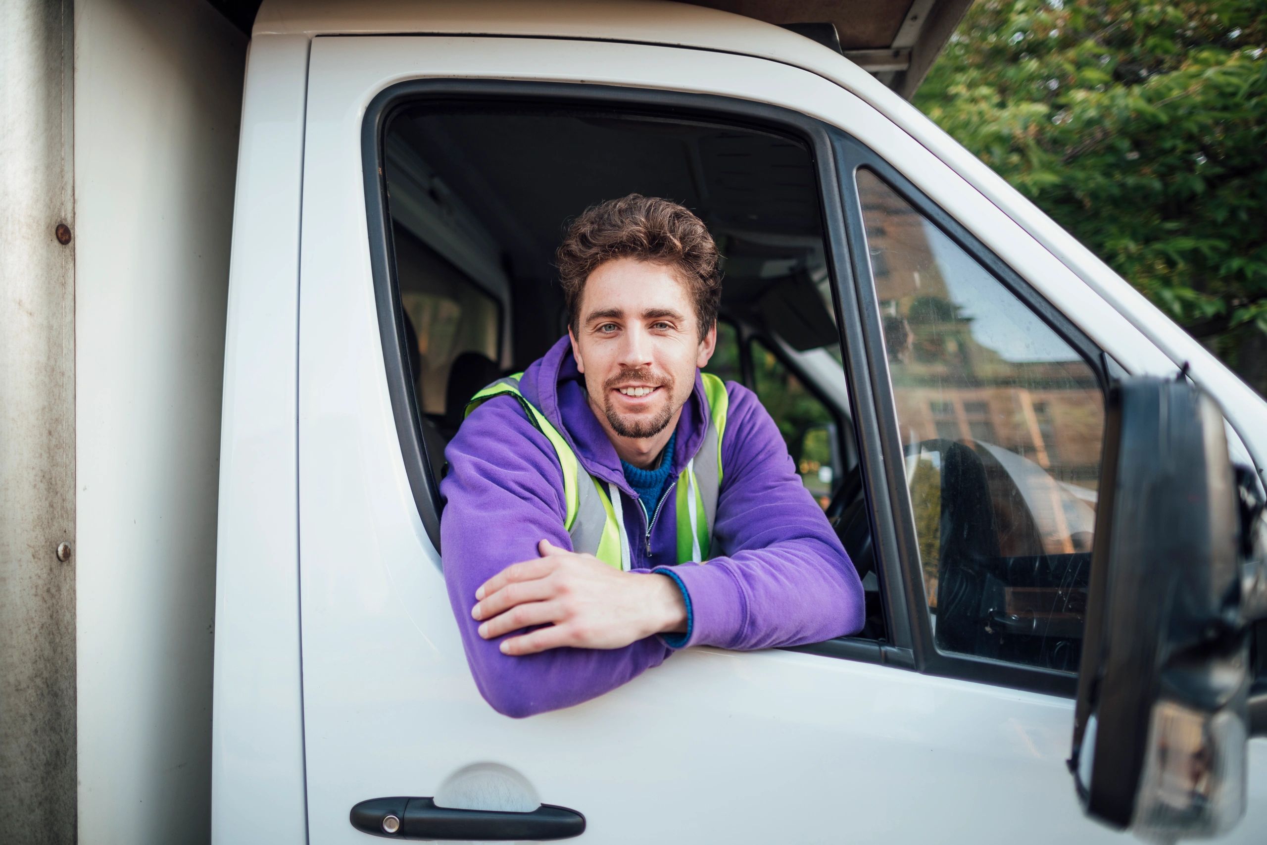 Technician seated in a service vehicle using work tools and preparing for a field visit