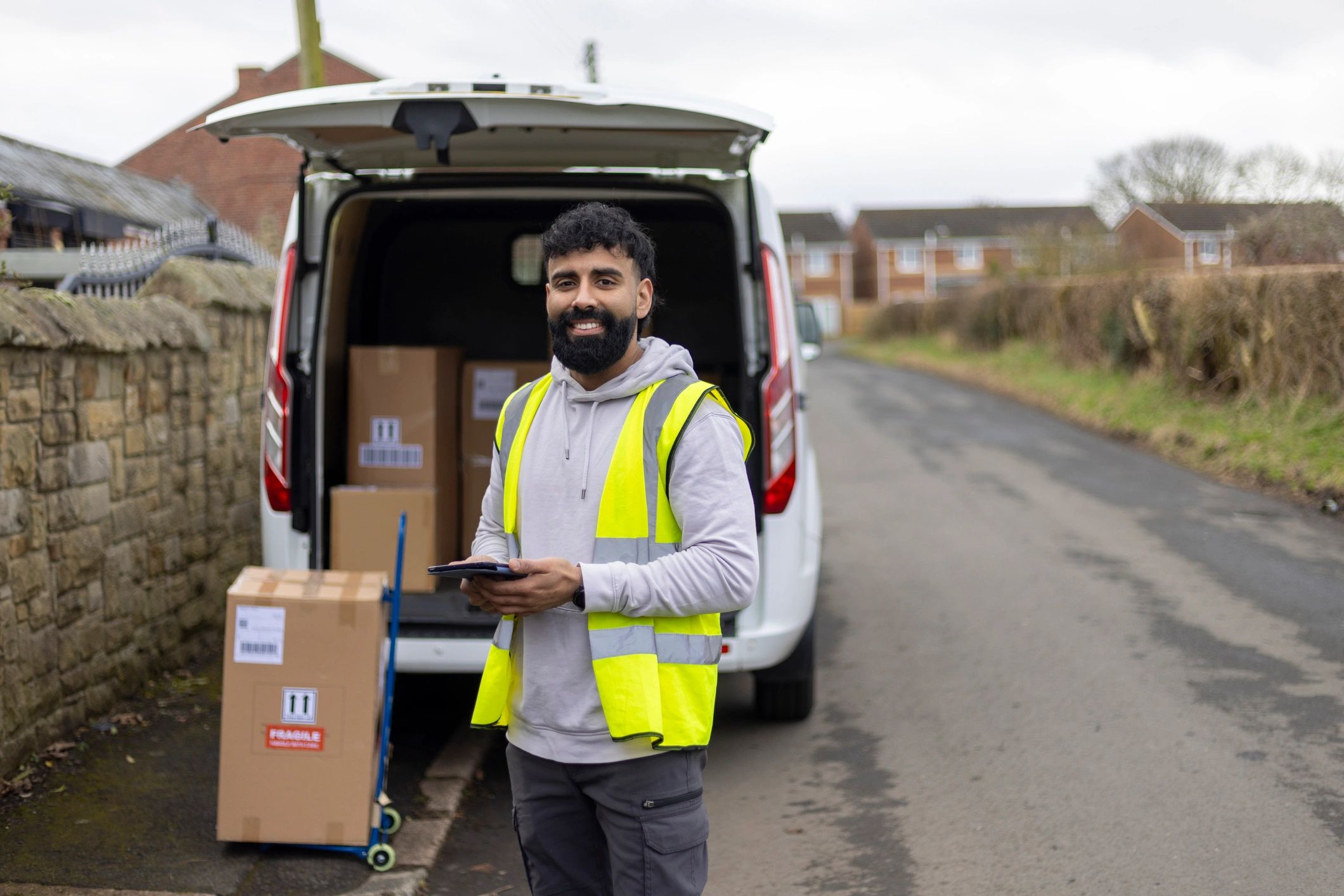 Mobile field technician standing beside a service vehicle with a tablet